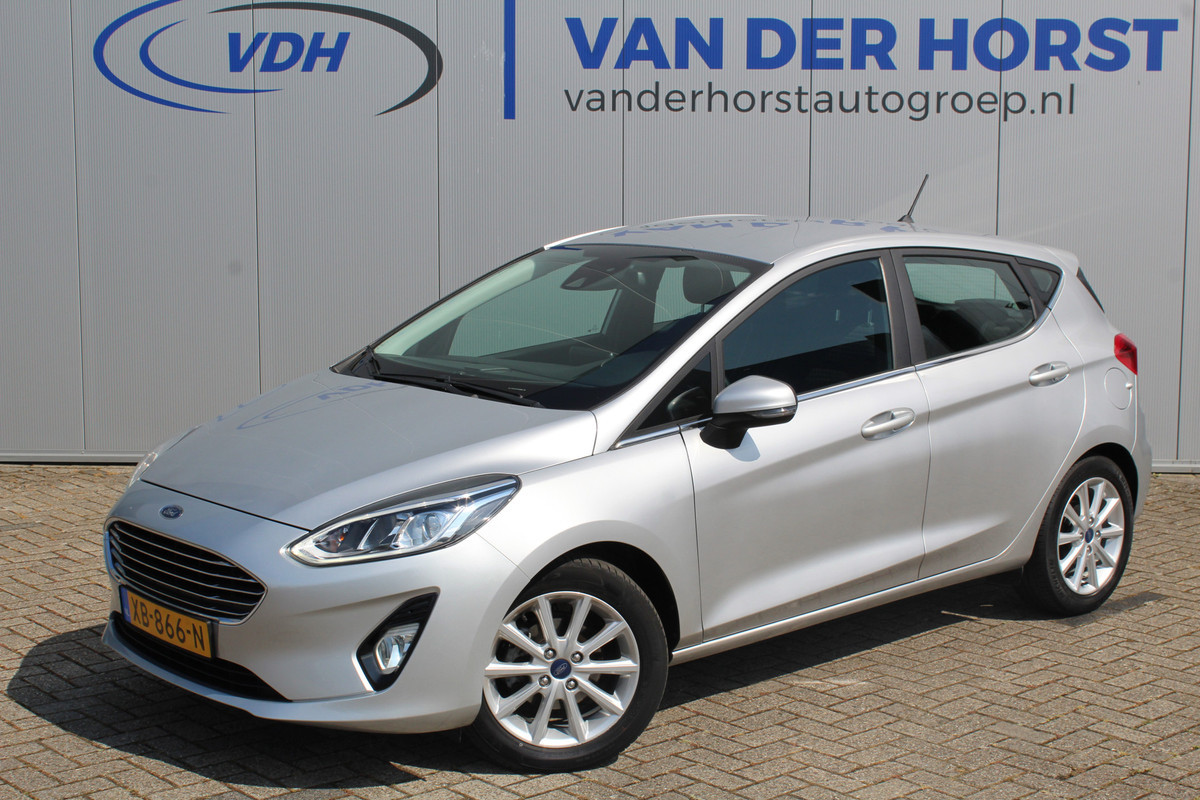 Ford Fiesta 1.0-100pk EcoBoost Titanium 5drs. Uiterst nette, luxe en zuinige Ford Fiesta. Voalautm. airco, Cruise control, Navigatie, LM wielen, Metallic lak, Parkeersensoren achter, Telefoonvoorb., Lane assist etc.