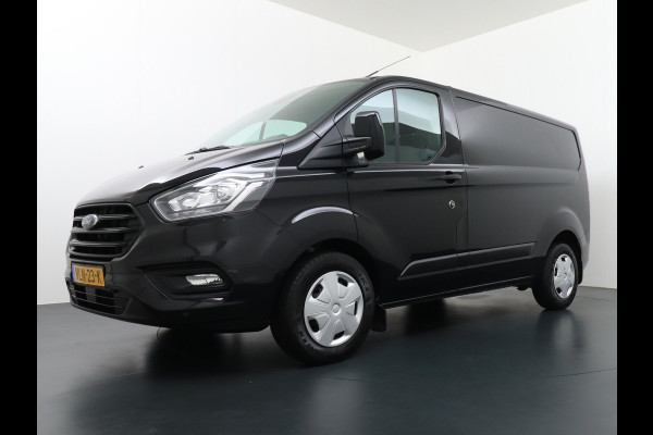 Ford Transit Custom 2.0D 130PK L1H1 3pers. Airco PDC-a+v Trekhaak Cruise-Controle voorruit verwarmbaar Betonplex Schuifdeur-r Tussenwand voorruit ve Adaptieve bochtverl. Projector-koplamp mistlampen regen-/lichtsensor Dieselroetfilter Supervergrendeling EURO 6 385Nm 2.500kg Trekvermogen!