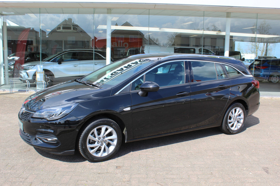 Opel Astra Sports Tourer 1.2-110pk Elegance. Ruime, sportieve, luxe en degelijke gezinswagen ! Autm. airco, stoel- en stuurwiel verw., LED verl., camera, parkeersens. v+a, metallic lak, LM wielen, Apple carplay/Android auto, navigatie, telefoonvoorb., cruise cntrl etc.