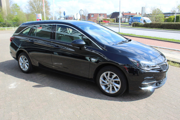 Opel Astra Sports Tourer 1.2-110pk Elegance. Ruime, sportieve, luxe en degelijke gezinswagen ! Autm. airco, stoel- en stuurwiel verw., LED verl., camera, parkeersens. v+a, metallic lak, LM wielen, Apple carplay/Android auto, navigatie, telefoonvoorb., cruise cntrl etc.