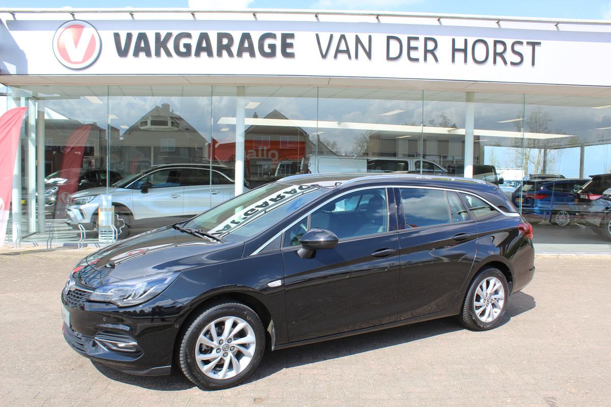 Opel Astra Sports Tourer 1.2-110pk Elegance. Ruime, sportieve, luxe en degelijke gezinswagen ! Autm. airco, stoel- en stuurwiel verw., LED verl., camera, parkeersens. v+a, metallic lak, LM wielen, Apple carplay/Android auto, navigatie, telefoonvoorb., cruise cntrl etc.