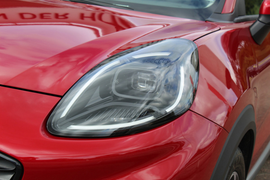 Ford Puma 1.0 125 pk EcoBoost Hybrid Titanium. Nieuw Model ! Erg fijn rijdende comfortabele hoogzitter ! Slechts 5.750km ! Fab.Gar. t/m 31-01-2029 ! Stoel-, stuur- en voorraamverwarming, Side- en laneassist, Camera rondom, Metallic lak, Navigatie, Telefoonvoorb. etc