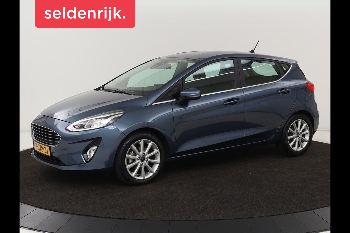 Ford Fiesta 1.0 EcoBoost Titanium | Stoel & stuurverwarming | Trekhaak | Carplay | Climate control | Cruise control | Verwarmde voorruit | Parkeerhulp Ford Fiesta 1.0 EcoBoost Titanium | Stoel & stuurverwarming | Trekhaak | Carplay | Climate control | Cruise control | Verwarmde voorruit | Parkeerhulp