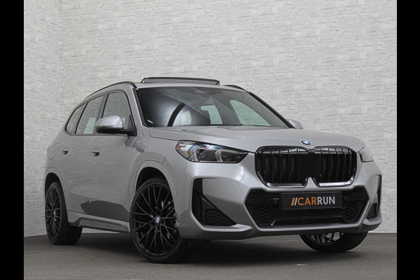 BMW X1 18i M-Sport | Panorama | Sportstoelen | Keyless-Entry | Sfeerverlichting | Achteruitrij-Camera | Carplay | Full-LED | Black-Optic | Getint Glas | Stoelverwarming | Draadloos Laden |