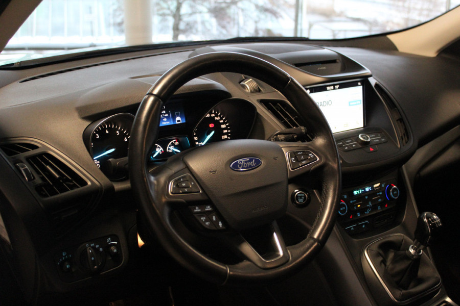 Ford Kuga 1.5-150pk EcoBoost Titanium. Nette Ford Kuga met een trekgewicht van maar liefst 2.000kg ! Autm. airco, stoel-, stuur- en voorraamverw., camera, parkeersensoren achter, navigatie, telefoonvoorb.,  17"LM wielen+all season banden, trekhaak, adapt. cruise cntrl etc.