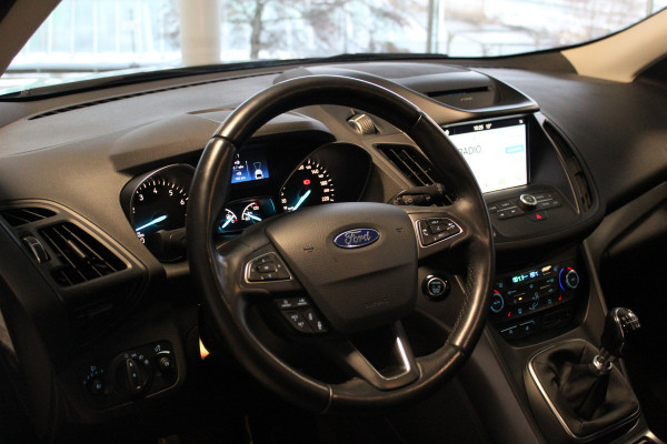 Ford Kuga 1.5-150pk EcoBoost Titanium. Nette Ford Kuga met een trekgewicht van maar liefst 2.000kg ! Autm. airco, stoel-, stuur- en voorraamverw., camera, parkeersensoren achter, navigatie, telefoonvoorb.,  17"LM wielen+all season banden, trekhaak, adapt. cruise cntrl etc.