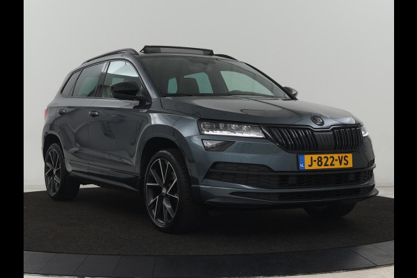 Škoda Karoq 1.5 TSI Sportline | Panoramadak | Trekhaak | Stoelverwarming | Camera | Carplay | Virtual Cockpit | Canton Sound | 19'' | Parkeerhulp | Navigatie | Sfeerverlichting | Cruise control | Stuurverwarming