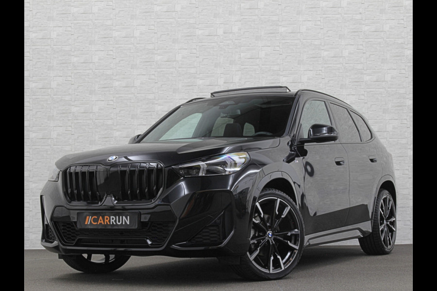 BMW X1 18i M-Sport | Panorama | Sportstoelen | Keyless-Entry | Sfeerverlichting | Achteruitrij-Camera | 5x op voorraad | Carplay | Full-LED | Black-Optic | Getint Glas | Stoelverwarming | Draadloos Laden |