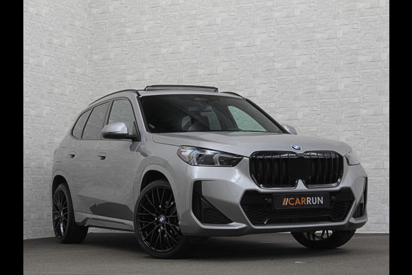 BMW X1 18i M-Sport | Panorama | Sportstoelen | Keyless-Entry | Sfeerverlichting | Achteruitrij-Camera | 5x op voorraad! | Carplay | Full-LED | Black-Optic | Getint Glas | Stoelverwarming | Draadloos Laden |