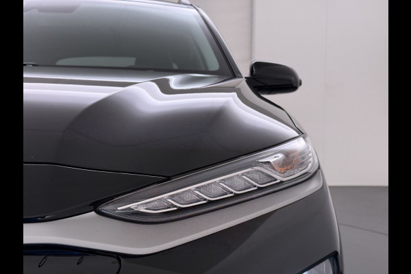 Hyundai Kona EV 64kWh 204pk SOH 100% Premium Schuif-/Kanteldak Leer Warmtepomp Head-Up Display Apple Carplay Android Navi Camera Elektr.Stoel Pdc Subwoofer Bluetooth Dodehoek detector Privacy Glas Rijstrooksensor 1e Eigenaar Origineel Nederlandse Auto Volledig Dealeronderhouden