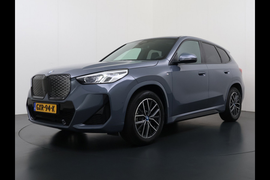 BMW iX1 eDrive20 67kWh M Sport pakket Pano-Dak/Schuif-dak Leer SOH 100% Warmtepomp Camera Navi Ecc PDC-a+v Apple Carplay Android Auto Elek.Achterklep Zwarte-Hemel VerkeersbordHerkenning WiFi M Aerodynamica  Lmv Led Privacy Glas Isofix DAB Keyless Wifi 1e Eigenaar Origineel Nederlandse Auto !!