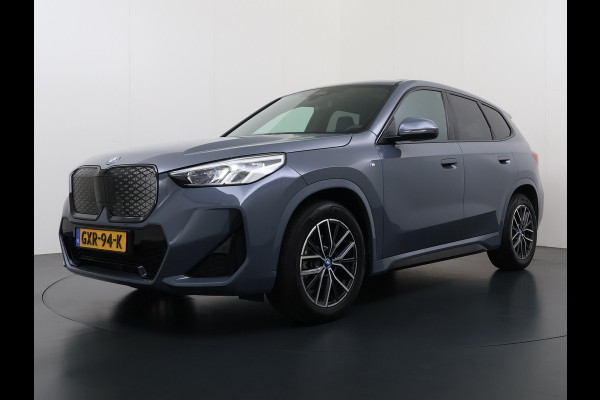 BMW iX1 eDrive20 67kWh M Sport pakket Pano-Dak/Schuif-dak Leer SOH 100% Warmtepomp Camera Navi Ecc PDC-a+v Apple Carplay Android Auto Elek.Achterklep Zwarte-Hemel VerkeersbordHerkenning WiFi M Aerodynamica  Lmv Led Privacy Glas Isofix DAB Keyless Wifi 1e Eigenaar Origineel Nederlandse Auto !!