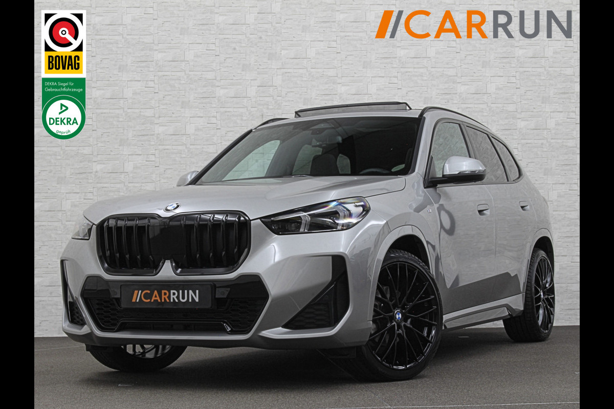 BMW X1 18i M-Sport | Panorama | Sportstoelen | Keyless-Entry | Sfeerverlichting | Achteruitrij-Camera | 5x op voorraad! | Carplay | Full-LED | Black-Optic | Getint Glas | Stoelverwarming | Draadloos Laden |