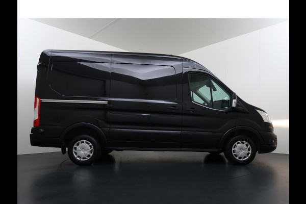 Ford Transit 310 2.0 TDCI L2H2 3-Persoons Camera Airco Stoelverwarming Elek.Stoel Cruise Control Pdc Lane Assist Trend Betonplex Vloer Wandbetimmering Schuifdeur Voorruitverwarming 1e Eigenaar Origineel Nederlandse Bus
