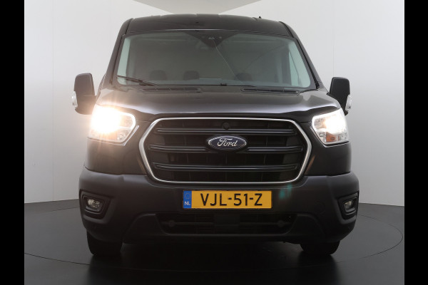 Ford Transit 310 2.0 TDCI L2H2 3-Persoons Camera Airco Stoelverwarming Elek.Stoel Cruise Control Pdc Lane Assist Trend Betonplex Vloer Wandbetimmering Schuifdeur Voorruitverwarming 1e Eigenaar Origineel Nederlandse Bus