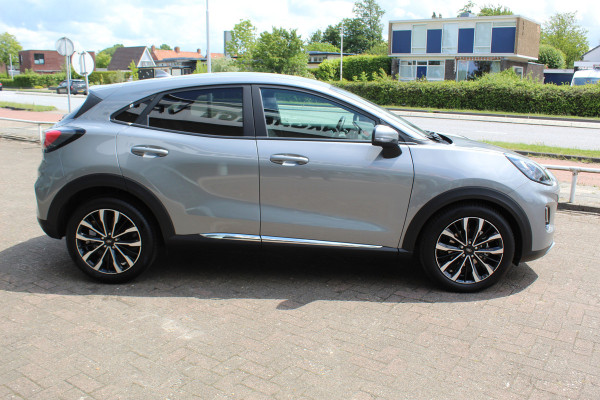Ford Puma 1.0-125pk EcoBoost Mild-Hybrid Titanium X. Garantie t/m 07-03-2028 ! Slechts 7.400km ! Cruise cntrl, climate cntrl, stoel-, stuur- en voorraamverw., draadloos opladen telefoon, trekhaak afneembaar, navigatie, telefoonvoorb., LM wielen, B&O soundsyst., digitaal dashboard etc.