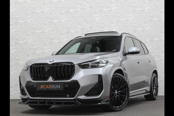 BMW X1 18i M-Sport Performance-Pack | Panorama | Sportstoelen | Carbon | Keyless-Entry | Sfeerverlichting | Achteruitrij-Camera | 5x op voorraad | Carplay | Full-LED | Black-Optic | Getint Glas | Stoelverwarming | Draadloos Laden |