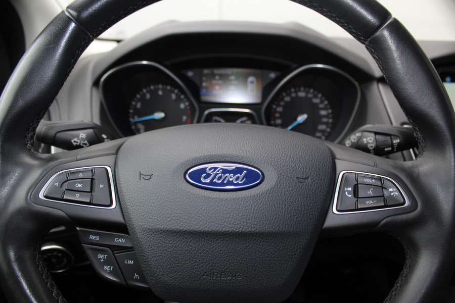 Ford Focus 1.0-125pk Titanium. Erg nette en luxe Ford Focus. Stoel-, stuur- en voorraamverw., autm. airco dual, navigatie, metallic lak, telefoonvoorb., camera, pdc v+a, dodehoek assist, AllSeason banden rondom, trekhaak, LM wielen etc.