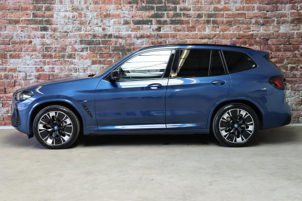 BMW iX3 High Executive M Sport Pakket 80 kWh / Live Cockpit Professional / Active Protection / Driving Assistant Professional / Panoramadak / Trekhaak / Leder / Adaptieve LED-koplamp / Shadow Line / Adaptief Onderstel /  Stuurwielverwarming / Head-Up Display / DAB / Harman Kardon