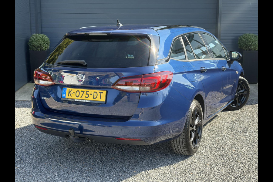 Opel Astra Sports Tourer 1.2 Ultimate 2e Eigenaar l Trekhaak l Camera l Carplay l Navi l Alcantara-Leder l 17''Lmv l Stoelverw-Stuurverw l Net beurt gehad l Dodehoek l Rijstrooksensor l Pdc V+A l 6 Bak l N.A.P l 146pk l Bj 11-2020 l Apk tot 08-2028