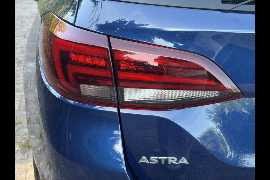 Opel Astra Sports Tourer 1.2 Ultimate 2e Eigenaar l Trekhaak l Camera l Carplay l Navi l Alcantara-Leder l 17''Lmv l Stoelverw-Stuurverw l Net beurt gehad l Dodehoek l Rijstrooksensor l Pdc V+A l 6 Bak l N.A.P l 146pk l Bj 11-2020 l Apk tot 08-2028