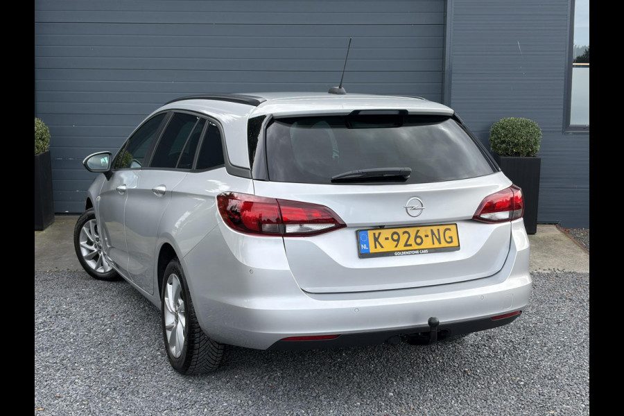 Opel Astra Sports Tourer 1.2 Business Executive ✓1e Eigenaar✓146pk✓Camera✓Trekhaak✓Carplay✓Airco✓Cruise✓Pdc V+A✓Lm velgen✓Comfortstoelen✓6 Bak✓N.A.P✓Nieuwe Apk bij Aflevering