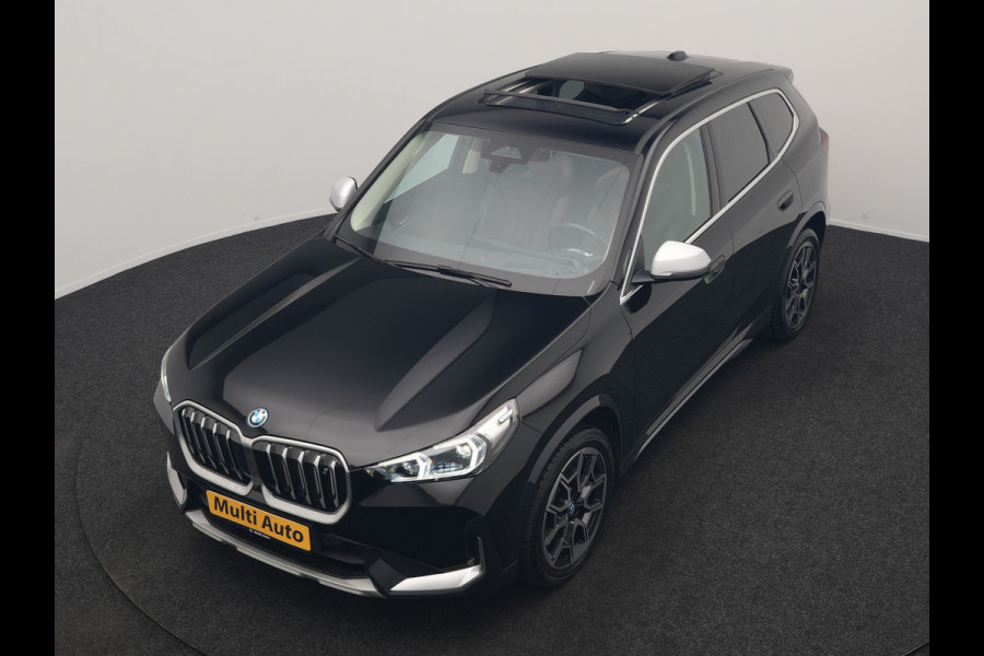 BMW iX1 xDrive30 X Line 67 kWh 313pk Dealer O.H. | Trekhaak Af Fabriek | Panodak | Head Up | Adaptive Cruise | 360 Camera | Harman / Kardon | Lederen Sportstoelen Massage & Memory | Keyless | Sfeerverlichting | Stoelen & Stuur Verwarmd | Apple Carplay | Widescreen Navi | DAB | 19"L.M |