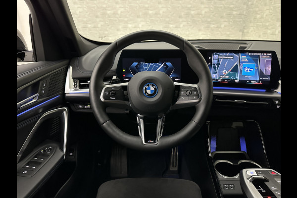 BMW iX1 30 313pk X-Drive M-Sport Performance | Adaptief Led | Sportstoelen | Keyless | 35390,= Exl. BTW | 4WD | Adaptieve Cruise en Struurwielverw. voorbereid | Antraciet Hemel | Carplay | Sfeerverlichting | 1200kg Trekgewicht | Camera | Bovag Garantie.