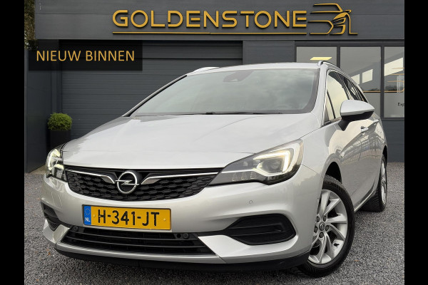 Opel Astra Sports Tourer 1.2 Elegance ✓110pk✓Camera✓Carplay✓Navi✓Halfleder✓Keyless✓Trekhaak✓Pdc V+A✓Clima✓Cruise✓Elekt Stoel✓Recent beurt gehad✓Dodehoeksensor✓Rijstrooksensor✓Lm velgen✓N.A.P✓Apk tot 11-2027