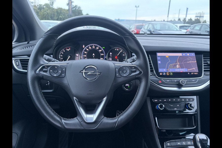 Opel Astra Sports Tourer 1.2 Elegance ✓110pk✓Camera✓Carplay✓Navi✓Halfleder✓Keyless✓Trekhaak✓Pdc V+A✓Clima✓Cruise✓Elekt Stoel✓Recent beurt gehad✓Dodehoeksensor✓Rijstrooksensor✓Lm velgen✓N.A.P✓Apk tot 11-2027