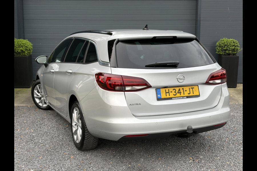 Opel Astra Sports Tourer 1.2 Elegance ✓110pk✓Camera✓Carplay✓Navi✓Halfleder✓Keyless✓Trekhaak✓Pdc V+A✓Clima✓Cruise✓Elekt Stoel✓Recent beurt gehad✓Dodehoeksensor✓Rijstrooksensor✓Lm velgen✓N.A.P✓Apk tot 11-2027