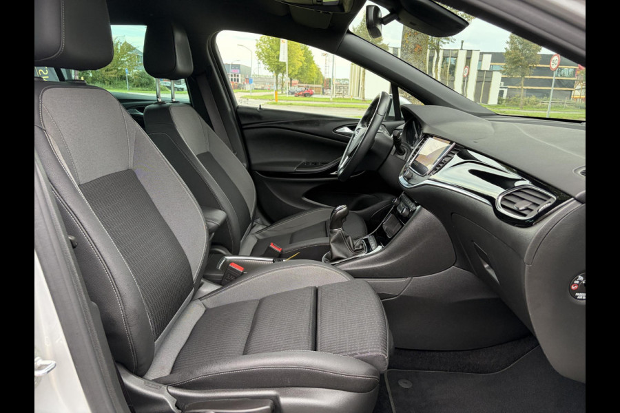 Opel Astra Sports Tourer 1.2 Elegance ✓110pk✓Camera✓Carplay✓Navi✓Halfleder✓Keyless✓Trekhaak✓Pdc V+A✓Clima✓Cruise✓Elekt Stoel✓Recent beurt gehad✓Dodehoeksensor✓Rijstrooksensor✓Lm velgen✓N.A.P✓Apk tot 11-2027