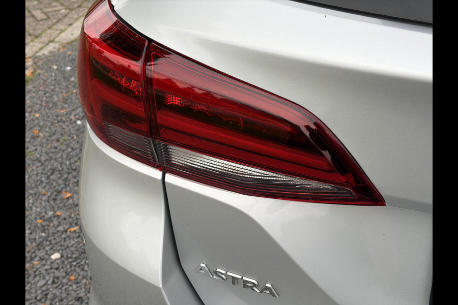 Opel Astra Sports Tourer 1.2 Elegance ✓110pk✓Camera✓Carplay✓Navi✓Halfleder✓Keyless✓Trekhaak✓Pdc V+A✓Clima✓Cruise✓Elekt Stoel✓Recent beurt gehad✓Dodehoeksensor✓Rijstrooksensor✓Lm velgen✓N.A.P✓Apk tot 11-2027