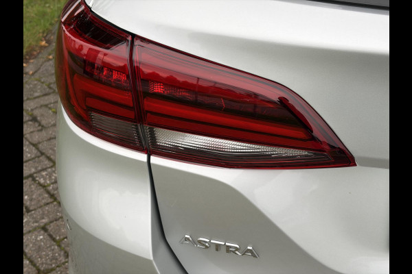 Opel Astra Sports Tourer 1.2 Elegance ✓110pk✓Camera✓Carplay✓Navi✓Halfleder✓Keyless✓Trekhaak✓Pdc V+A✓Clima✓Cruise✓Elekt Stoel✓Recent beurt gehad✓Dodehoeksensor✓Rijstrooksensor✓Lm velgen✓N.A.P✓Apk tot 11-2027