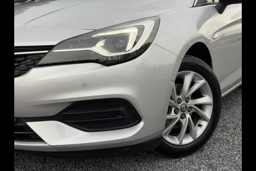 Opel Astra Sports Tourer 1.2 Elegance ✓110pk✓Camera✓Carplay✓Navi✓Halfleder✓Keyless✓Trekhaak✓Pdc V+A✓Clima✓Cruise✓Elekt Stoel✓Recent beurt gehad✓Dodehoeksensor✓Rijstrooksensor✓Lm velgen✓N.A.P✓Apk tot 11-2027