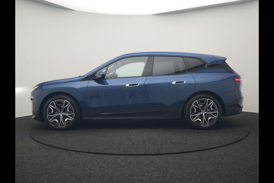 BMW iX xDrive40 Excellence 77 kWh 327pk | SOH 96,9% | Trekhaak Af Fabriek | Panodak Sky Lounge | Adaptive Cruise | Head Up | 360 Camera | Harman / Kardon | Lederen Sportstoelen & Stuur Verwarmd | Sfeerverlichting | BLIS | Keyless |