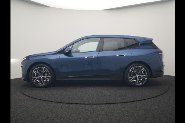 BMW iX xDrive40 Excellence 77 kWh 327pk | SOH 96,9% | Trekhaak Af Fabriek | Panodak Sky Lounge | Adaptive Cruise | Head Up | 360 Camera | Harman / Kardon | Lederen Sportstoelen & Stuur Verwarmd | Sfeerverlichting | BLIS | Keyless |