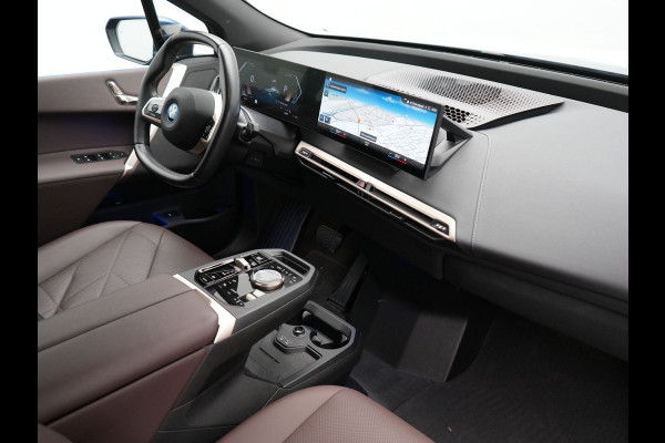 BMW iX xDrive40 Excellence 77 kWh 327pk | SOH 96,9% | Trekhaak Af Fabriek | Panodak Sky Lounge | Adaptive Cruise | Head Up | 360 Camera | Harman / Kardon | Lederen Sportstoelen & Stuur Verwarmd | Sfeerverlichting | BLIS | Keyless |