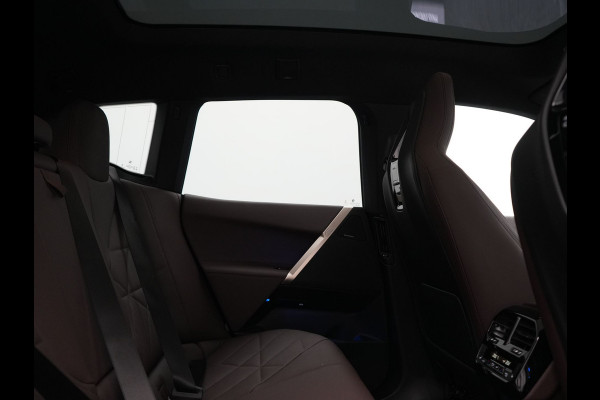 BMW iX xDrive40 Excellence 77 kWh 327pk | SOH 96,9% | Trekhaak Af Fabriek | Panodak Sky Lounge | Adaptive Cruise | Head Up | 360 Camera | Harman / Kardon | Lederen Sportstoelen & Stuur Verwarmd | Sfeerverlichting | BLIS | Keyless |