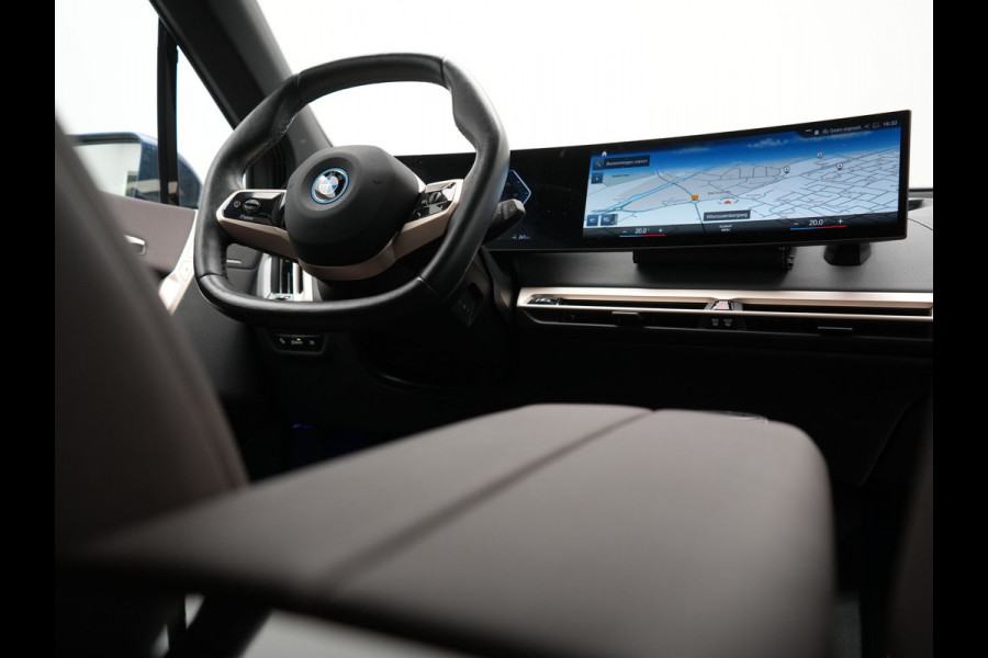 BMW iX xDrive40 Excellence 77 kWh 327pk | SOH 96,9% | Trekhaak Af Fabriek | Panodak Sky Lounge | Adaptive Cruise | Head Up | 360 Camera | Harman / Kardon | Lederen Sportstoelen & Stuur Verwarmd | Sfeerverlichting | BLIS | Keyless |