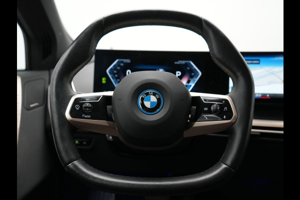 BMW iX xDrive40 Excellence 77 kWh 327pk | SOH 96,9% | Trekhaak Af Fabriek | Panodak Sky Lounge | Adaptive Cruise | Head Up | 360 Camera | Harman / Kardon | Lederen Sportstoelen & Stuur Verwarmd | Sfeerverlichting | BLIS | Keyless |