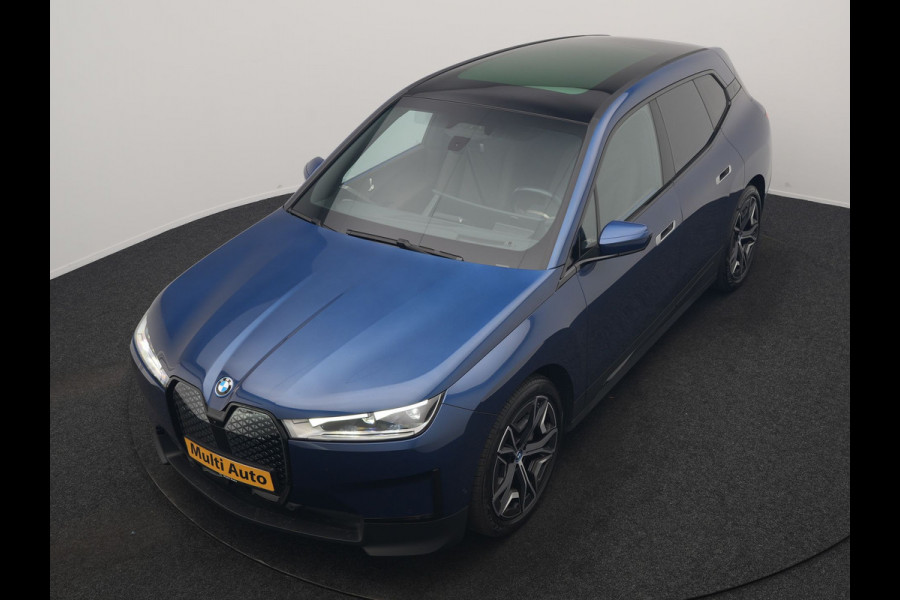 BMW iX xDrive40 Excellence 77 kWh 327pk | SOH 96,9% | Trekhaak Af Fabriek | Panodak Sky Lounge | Adaptive Cruise | Head Up | 360 Camera | Harman / Kardon | Lederen Sportstoelen & Stuur Verwarmd | Sfeerverlichting | BLIS | Keyless |
