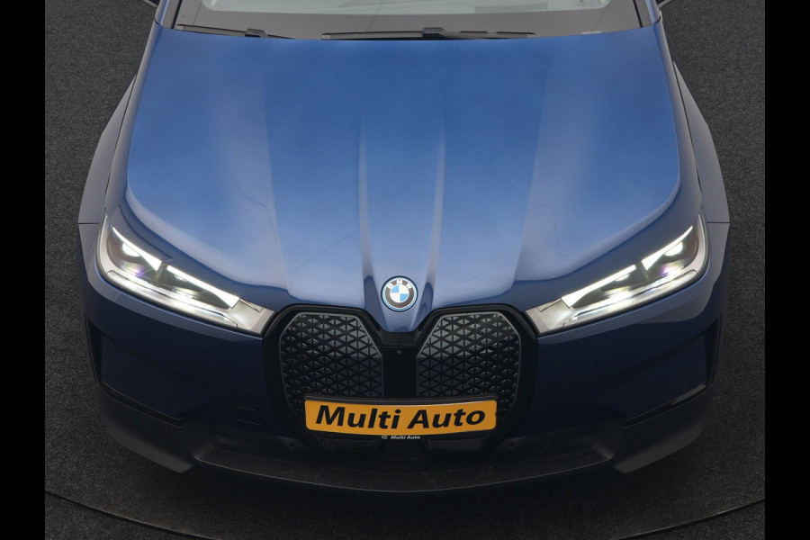 BMW iX xDrive40 Excellence 77 kWh 327pk | SOH 96,9% | Trekhaak Af Fabriek | Panodak Sky Lounge | Adaptive Cruise | Head Up | 360 Camera | Harman / Kardon | Lederen Sportstoelen & Stuur Verwarmd | Sfeerverlichting | BLIS | Keyless |