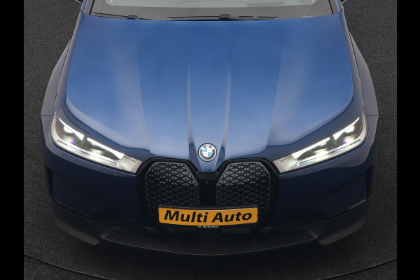 BMW iX xDrive40 Excellence 77 kWh 327pk | SOH 96,9% | Trekhaak Af Fabriek | Panodak Sky Lounge | Adaptive Cruise | Head Up | 360 Camera | Harman / Kardon | Lederen Sportstoelen & Stuur Verwarmd | Sfeerverlichting | BLIS | Keyless |