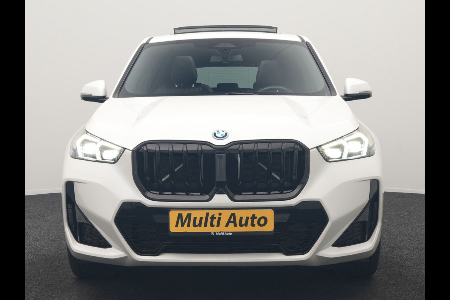 BMW iX1 xDrive30 M Sport 313pk Dealer O.H. | Trekhaak Af Fabriek | Panodak | 360 Camera | Head Up | Lederen Sportstoelen Memory & Verwarmd | Stuur Verwarmd | Keyless | BLIS | Sfeerverlichting | Apple Carplay | Navigatie | DAB | 20"L.M