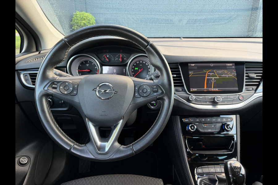 Opel Astra Sports Tourer 1.4 Innovation ✓Trekhaak✓Camera✓Carplay✓Navi✓Recent beurt gehad✓150pk✓Keyless✓Halfleder✓6 Bak✓Rijstrooksensor✓Dodehoeksensor✓Pdc V+A✓Lm velgen✓Clima✓Cruise✓N.A.P✓Apk tot 09-2027