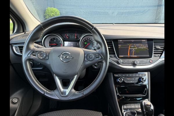 Opel Astra Sports Tourer 1.4 Innovation ✓Trekhaak✓Camera✓Carplay✓Navi✓Recent beurt gehad✓150pk✓Keyless✓Halfleder✓6 Bak✓Rijstrooksensor✓Dodehoeksensor✓Pdc V+A✓Lm velgen✓Clima✓Cruise✓N.A.P✓Apk tot 09-2027