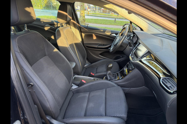 Opel Astra Sports Tourer 1.4 Innovation ✓Trekhaak✓Camera✓Carplay✓Navi✓Recent beurt gehad✓150pk✓Keyless✓Halfleder✓6 Bak✓Rijstrooksensor✓Dodehoeksensor✓Pdc V+A✓Lm velgen✓Clima✓Cruise✓N.A.P✓Apk tot 09-2027