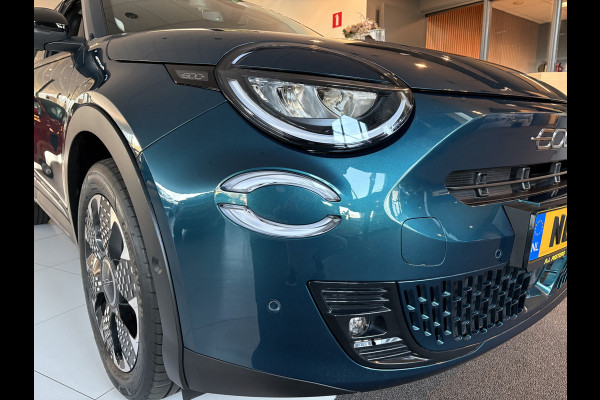 Fiat 600E La Prima 54 kWh Achteruitrijcamera - Apple carplay - Airco - Draadloze telefoonlader - Parkeersensoren - Navigatie - Licht metalen velgen 18 inch - Stoelverwarming - Voorstoelen met massagefunctie - Led verlichting - Mistlampen - Stuur multifunctioneel - Bluetooth - Cruise control - Dodehoekdetectie - Elektrische ramen - Extra getint glas achter - Keyless start/entry