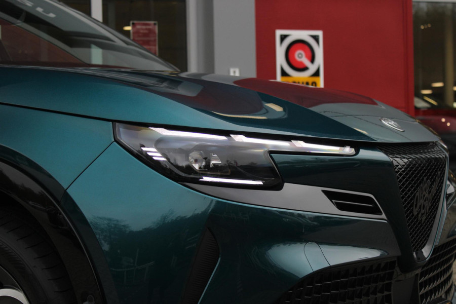 Alfa Romeo junior ELETTRICA SPORT SPECIALE 156PK 54 kWh | PANORAMA SCHUIF/KANTEL DAK | TECHNO PACK: (LED MATRIX KOPLAMPEN, DRAADLOZE TELEFOONLADER, DODEHOEK DETECTIE, PARKEERSENSOREN VOOR ACHTER EN ZIJKANT, NAVIGATIE, ELEKTRISCH BEDIENBARE ACHTERKLEP, KEYLESS ENTRY, ADAPTIVE CRUISE CONTROL, ACHTERUITRIJ CAMERA) | SPORT SPECIALE BEKLEDING MET ALCANTARA | WAMRTEPOMP! | VERWARMBARE VOORSTOELEN | VERWARMBARE VOORRUIT | NAVIGLI BLUE MET ZWART DAK | 18" LICHTMETALEN VELGEN "FOGRI" | GRILL "LEGGENDA" | 100 KW DC SNELLADER | 3-FASE | ELEKTRISCH VERSTELBARE BESTUURDERSSTOEL MET MASSAGE FNCTIE |